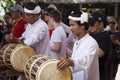 Musician in white clothes playing on traditional drum