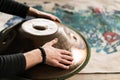 A musician& x27;s hand playing the handpan with other people.