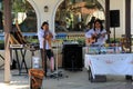 Musicians entertaining people passing by in outdoor shopping center, California, 2016