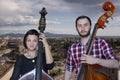 Musicians play the violin and contrabass Image on the background of the city