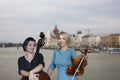 Musicians play the violin and contrabass Image on the background of the city
