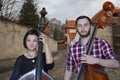 Musicians play the violin and contrabass Image on the background of the city