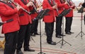 Musicians in red suits play at a street concert