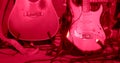 The musicians' guitars stand in red light on the stage. Coiled wires with plugs. Royalty Free Stock Photo