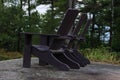 Muskoka or Adirondack Chairs at the end of a pier overlooking a large blue lake with a blue sky Royalty Free Stock Photo