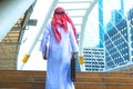 Muslim Arab man. He standing hold bag and document.