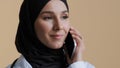 Muslim arabian young female doctor intern woman surgeon practitioner wear medical coat hijab talk by cellphone islamic