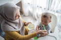 Mother feeding her baby boy while sitting on high chair Royalty Free Stock Photo