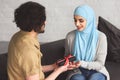 muslim boyfriend presenting gift box to girlfriend