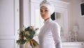 Muslim bride in white wedding dress holding the bouquet of flowers in hand Royalty Free Stock Photo