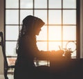 Muslim business people silhouette of islam woman working on office table windows morning flare