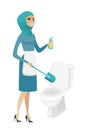 Muslim cleaner in uniform cleaning toilet bowl.