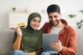 Muslim Couple Doing Online Shopping Via Digital Tablet At Home Royalty Free Stock Photo