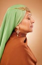 Muslim, culture clothes and senior woman with jewelry, faith and hijab against a brown studio background. Islamic