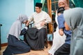muslim daughter kneel and shake their parent's hand asking for forgiveness