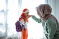 Muslim daughter shake hand and kiss mother before going to school