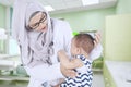 Muslim doctor examining a baby