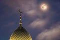 A Muslim dome with a crescent moon on the mosque. Minaret on the background of the moon. The Arabian night. Islamic symbols of