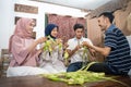 muslim family and friend making ketupat for eid fitr mubarak