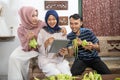 muslim family and friend making ketupat for eid fitr mubarak