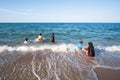 Muslim family playing in ocean surf on sunny summer