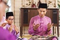 Muslim family saying prayers before meal