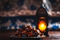 The Muslim feast of the holy month of Ramadan Kareem. Beautiful background with a shining lantern Fanus and dried dates on wooden Royalty Free Stock Photo