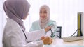 Muslim female doctor checking up patient`s blood pressure at hospital room Royalty Free Stock Photo