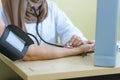 Muslim female doctor using sphygmomanometer with stethoscope checking blood pressure to patient in the hospital Royalty Free Stock Photo