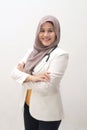 Muslim female doctor wearing hijab and suit, standing with crossed arm and holding stethoscope, succesful confident person Royalty Free Stock Photo