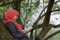 Muslim female student reading a book in nature, outdoor