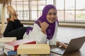 Muslim female university student lying on floor at home workin for reseach paper