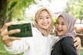 muslim friend taking selfie or video calling outdoor using her smart phone during sport break outdoor Royalty Free Stock Photo