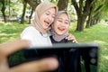 muslim friend taking selfie or video calling outdoor using her smart phone during sport break outdoor Royalty Free Stock Photo