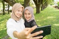 muslim friend taking selfie or video calling outdoor using her smart phone during sport break outdoor Royalty Free Stock Photo