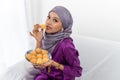 Muslim girl celebrates end of Ramadan, in purple dress, and holding food, portrait waist up Royalty Free Stock Photo