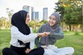 Muslim girl friends chatting intimately in the garden