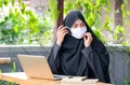 Muslim girl is wearing face mask during work with laptop and she still work at home during Covid-19 pandemic in many area