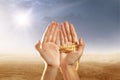 Muslim hands praying with prayer beads on desert