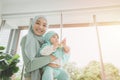 Muslim Hijab holding support her child baby happy smiling at home. mother care healthy infant looking camera Royalty Free Stock Photo