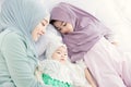 Muslim Hijab mother keep looking and cuddling sleeping baby with love and care on the bed Royalty Free Stock Photo