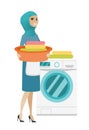 Muslim housewife using washing machine at laundry.