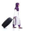 Muslim immigrant woman wearing a hijab walking carrying a suitcase Royalty Free Stock Photo