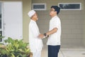 Muslim Indonesian father greets son arriving at the house Royalty Free Stock Photo