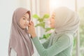 Muslim or Islam mother dressing hijab for her daughter at home in the morning