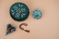 Muslim islamic faith concept taqiyah skullcap , red rosary, dates in the bowl in the Arabic style. Neutral beige background.