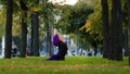 Muslim islamic woman practice yoga sun salutation in park on grass morning routine up facing dog pose asana for body Royalty Free Stock Photo