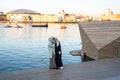 Muslim ladies look at phone standing near tranquil river