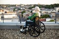 Muslim lady with phone taking in view of city in wheelchair