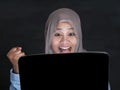 Muslim Lady Using Laptop Shows Winning Gesture, Receiving Good News on Her Email Royalty Free Stock Photo